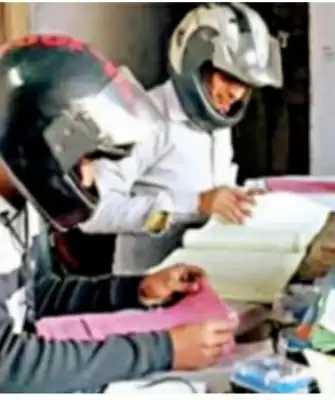 यूपी बिजली विभाग के ऑफिस में हेलमेट पहनकर काम कर रहे कर्मचारी