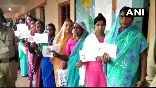 कर्नाटक : कर्नाटक में उपचुनाव के लिए वोटिंग शुरू लाइन में खड़े लोग