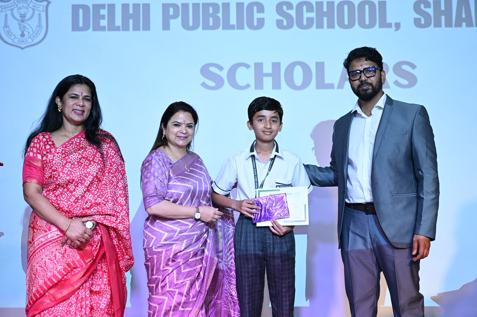 ज्ञान के प्रकाश से कार्यक्रम का आगाज़ समारोह का शुभारंभ मुख्य अतिथि डॉ. आदित्य कुमार शर्मा, प्रधानाचार्या डॉ. मंजू लखनपाल, उप प्रधानाचार्या स्वाति सिंह मल्होत्रा और प्रवेश संचालिका दिव्या सिंह की उपस्थिति में दीप प्रज्वलन के साथ हुआ। सकारात्मक ऊर्जा के प्रतीक दीप प्रज्वलन के पश्चात विद्यालय के विद्यार्थियों ने देशभक्ति से ओत-प्रोत 'वंदे मातरम्' की सुमधुर प्रस्तुति दी, जिससे पूरा परिसर राष्ट्रभक्ति के स्वर में सराबोर हो गया।  पुरस्कारों की बौछार: प्रतिभा और नियमितता का सम्मान कार्यक्रम के दौरान मेधावी छात्र-छात्राओं को उनकी शैक्षणिक उत्कृष्टता के लिए प्रतिष्ठित 'स्कॉलर बैज' प्रदान किए गए। सम्मान की श्रेणी में केवल पढ़ाई ही नहीं, बल्कि अन्य क्षेत्रों को भी शामिल किया गया:  शैक्षणिक उत्कृष्टता: सत्र 2025-26 के टॉपर्स को स्कॉलर बैज से नवाजा गया।  नियमितता: विद्यालय में 100% उपस्थिति दर्ज कराने वाले विद्यार्थियों को विशेष रूप से सम्मानित किया गया।  बहुमुखी प्रतिभा: खेल, कला और अन्य पाठ्येतर गतिविधियों में अपनी धाक जमाने वाले छात्रों को भी पुरस्कार मिले।  मुख्य अतिथि का प्रेरक संबोधन मुख्य अतिथि डॉ. आदित्य कुमार शर्मा ने अपने संबोधन में विद्यार्थियों को प्रेरित करते हुए कहा कि सफलता का कोई शॉर्टकट नहीं होता। उन्होंने छात्रों को निरंतर परिश्रम, अनुशासन और अटूट संकल्प के साथ जीवन के हर क्षेत्र में आगे बढ़ने का मंत्र दिया।  कृतज्ञता और राष्ट्रगान के साथ समापन समारोह के अंत में विद्यालय प्रशासन ने मुख्य अतिथि का आभार व्यक्त किया। कार्यक्रम का औपचारिक समापन सामूहिक राष्ट्रगान के साथ हुआ। अभिभावकों ने भी विद्यालय की इस पहल की सराहना की, जो बच्चों में स्वस्थ प्रतिस्पर्धा और बेहतर करने का जज़्बा पैदा करती है।