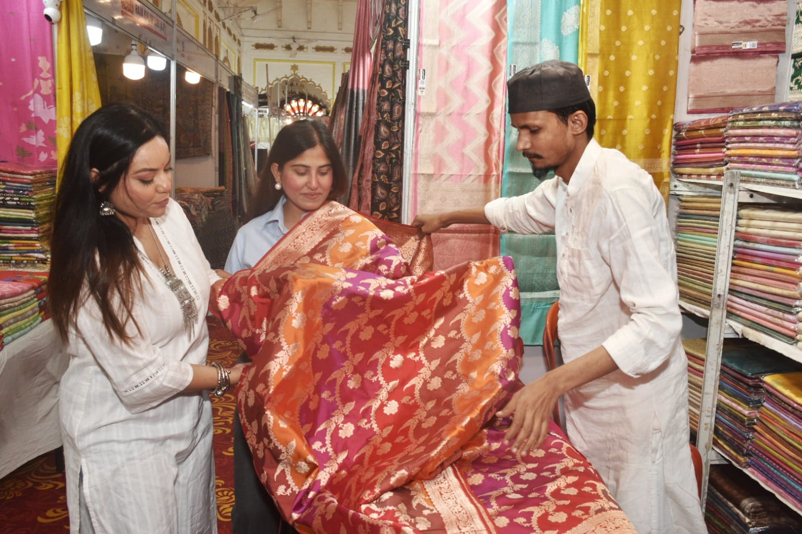 100 से अधिक मास्टर बुनकरों का संगम इस प्रदर्शनी की सबसे बड़ी खासियत यहाँ मौजूद विविधता है। देश के विभिन्न कोनों से आए 100 से अधिक अनुभवी मास्टर बुनकरों ने अपने हाथ से तैयार किए गए बेहतरीन उत्पादों का स्टॉल लगाया है।  पारंपरिक साड़ियाँ: यहाँ बनारसी, चंदेरी, कांजीवरम और टसर सिल्क का ऐसा संग्रह है जो देखते ही बनता है।  विशेष आकर्षण: कश्मीरी प्योर क्रेप और 'प्योर सिल्क मार्क' से प्रमाणित साड़ियाँ ग्राहकों की पहली पसंद बनी हुई हैं। पारंपरिक परिधानों के साथ-साथ आधुनिक फैशन के अनुरूप डिजाइन किए गए वस्त्र भी युवाओं को आकर्षित कर रहे हैं।  सीधे बुनकरों से खरीदारी का मौका आयोजक मानस आचार्य और जावेद मकसूद ने बताया कि इस प्रदर्शनी का मुख्य उद्देश्य बिचौलियों को हटाकर देश के बुनकरों को एक सशक्त मंच प्रदान करना है।  "ऐसी प्रदर्शनियों के माध्यम से भारतीय हस्तकरघा (Handloom) उद्योग को संजीवनी मिलती है। ग्राहक सीधे उन हाथों से संवाद कर पा रहे हैं जिन्होंने इन वस्त्रों को बुना है। इससे न केवल बुनकरों को उचित दाम मिलता है, बल्कि ग्राहकों को भी शुद्ध और उच्च गुणवत्ता वाले उत्पाद प्राप्त होते हैं।"  शहरवासियों के लिए खास अवसर सफेद बारादरी का ऐतिहासिक परिसर इस समय रंग-बिरंगे रेशम और सूती वस्त्रों की चमक से सराबोर है। आयोजकों ने लखनऊ वासियों से अपील की है कि वे इस प्रदर्शनी में आकर भारतीय सिल्क की समृद्ध विरासत का हिस्सा बनें और स्वदेशी उत्पादों को बढ़ावा दें।