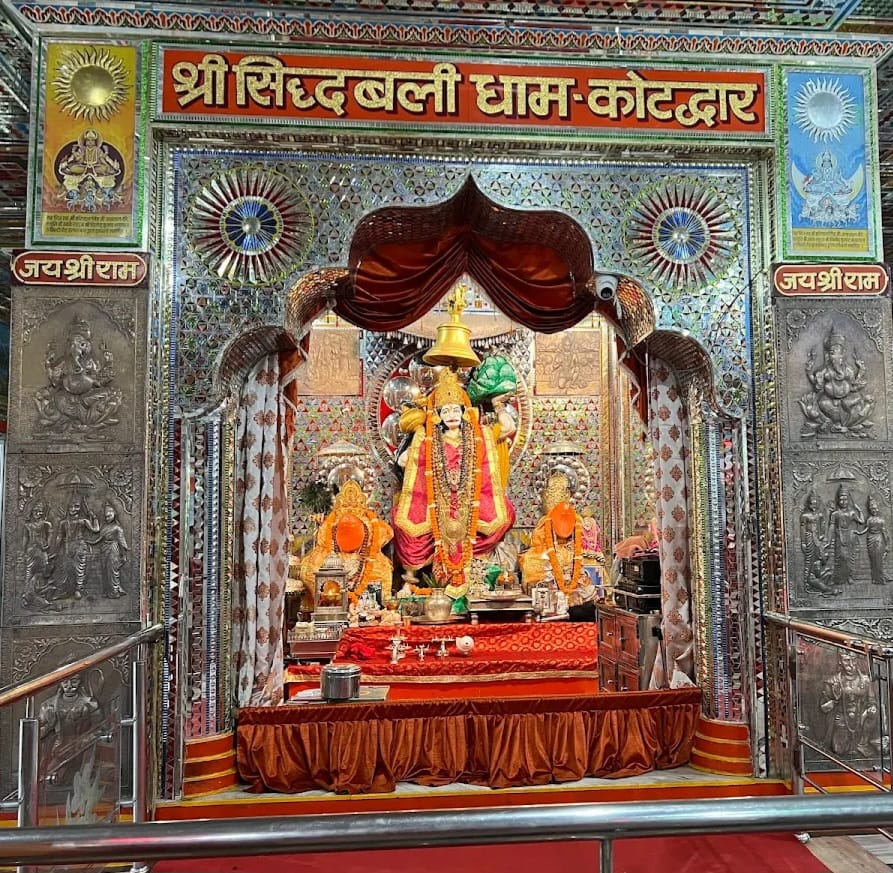 गुरु गोरखनाथ और हनुमान जी का अद्भुत प्रसंग  सिद्धबली धाम की स्थापना से जुड़ी पौराणिक कथा अत्यंत रोचक और श्रद्धा से परिपूर्ण है। मान्यता है कि इस पावन स्थल पर श्रीराम भक्त हनुमान, नाथ संप्रदाय के महान संत गुरु गोरखनाथ के आग्रह पर एक दिव्य प्रहरी के रूप में विराजमान हैं।  किंवदंती के अनुसार, एक समय गुरु गोरखनाथ अपने गुरु मत्स्येंद्रनाथ के साथ जनकल्याण के उद्देश्य से भ्रमण करते हुए इस वन क्षेत्र में पहुंचे। उसी समय भगवान हनुमान ने वेश बदलकर उनका मार्ग रोक लिया। इसके बाद गुरु गोरखनाथ और हनुमान जी के बीच एक अद्भुत एवं भीषण युद्ध हुआ। दोनों ही अजेय रहे। अंततः हनुमान जी अपने वास्तविक विराट स्वरूप में प्रकट हुए।  गुरु गोरखनाथ ने उन्हें आदरपूर्वक प्रणाम किया। तब हनुमान जी ने उनसे पूछा कि वे क्या चाहते हैं। इस पर गुरु गोरखनाथ ने विनम्रतापूर्वक निवेदन किया कि वे इस सिद्ध भूमि पर सदैव प्रहरी के रूप में निवास करें और जनमानस की रक्षा एवं कल्याण करें। हनुमान जी ने यह आग्रह स्वीकार कर लिया। तभी से यह तपोभूमि &lsquo;सिद्धबली&rsquo; के नाम से प्रसिद्ध हुई।  तपोभूमि, जहाँ सिद्धियों ने लिया आकार  लोकमान्यता है कि गुरु गोरखनाथ ने इसी पावन भूमि पर कठोर तपस्या कर अनेक दिव्य सिद्धियां प्राप्त की थीं। इसी कारण उनके अनुयायी और श्रद्धालु उन्हें &lsquo;सिद्ध बाबा&rsquo; के रूप में स्मरण करते हैं। कहा जाता है कि प्राचीन काल में अनेक ऋषि-मुनियों ने भी इस स्थान पर तपस्या कर भगवान हनुमान का आह्वान किया था। तभी से यह भूमि आध्यात्मिक ऊर्जा और दिव्य अनुभूतियों का केंद्र मानी जाती है।  डाक टिकट से मिली वैश्विक पहचान  सिद्धबली मंदिर की पौराणिक महत्ता और आध्यात्मिक प्रतिष्ठा को देखते हुए भारत सरकार के डाक विभाग ने वर्ष 2008 में इस मंदिर पर एक विशेष डाक टिकट जारी किया था। इस सम्मान के बाद सिद्धबली धाम को राष्ट्रीय ही नहीं, बल्कि अंतरराष्ट्रीय स्तर पर भी नई पहचान मिली। आज यह मंदिर धार्मिक पर्यटन के प्रमुख स्थलों में गिना जाता है।  मनोकामना पूर्ति और भंडारे की परंपरा  श्रद्धालुओं का विश्वास है कि जो भी भक्त सच्चे मन और पूर्ण श्रद्धा के साथ सिद्धबली धाम में आता है, उसकी मनोकामना अवश्य पूर्ण होती है। मनोकामना पूर्ण होने पर भक्त यहां विशाल भंडारे का आयोजन कर भगवान के प्रति अपनी कृतज्ञता प्रकट करते हैं।  मुख्य मंदिर परिसर में भगवान शिव का मनोहारी स्फटिक शिवलिंग, मां जगदंबा की प्रतिमा और शनि महाराज का मंदिर भी स्थापित है। इन मंदिरों की उपस्थिति इस संपूर्ण परिसर को और अधिक दिव्यता एवं आध्यात्मिक ऊर्जा से भर देती है।  हनुमान जयंती पर अद्भुत छटा  यद्यपि वर्ष भर सिद्धबली धाम में श्रद्धालुओं की भीड़ लगी रहती है, लेकिन हनुमान जयंती के अवसर पर यहां की छटा विशेष रूप से मनोहारी हो उठती है। भक्त कुछ सीढ़ियां चढ़कर जब पहाड़ी पर स्थित मंदिर तक पहुंचते हैं, तो उन्हें शांत वातावरण, पर्वतीय सौंदर्य और आध्यात्मिक ऊर्जा का अद्भुत अनुभव होता है।  सिद्धबली मंदिर केवल एक धार्मिक स्थल नहीं, बल्कि वह आस्था, प्रकृति और आध्यात्मिक अनुभूति का ऐसा तीर्थ है, जहां पहुंचकर मनुष्य स्वयं को ईश्वर के अधिक निकट अनुभव करता है। वास्तव में, आत्मिक शांति और श्रद्धा की अनुभूति के लिए कोटद्वार का सिद्धबली हनुमान दरबार एक अद्वितीय और वंदनीय तीर्थस्थल है।